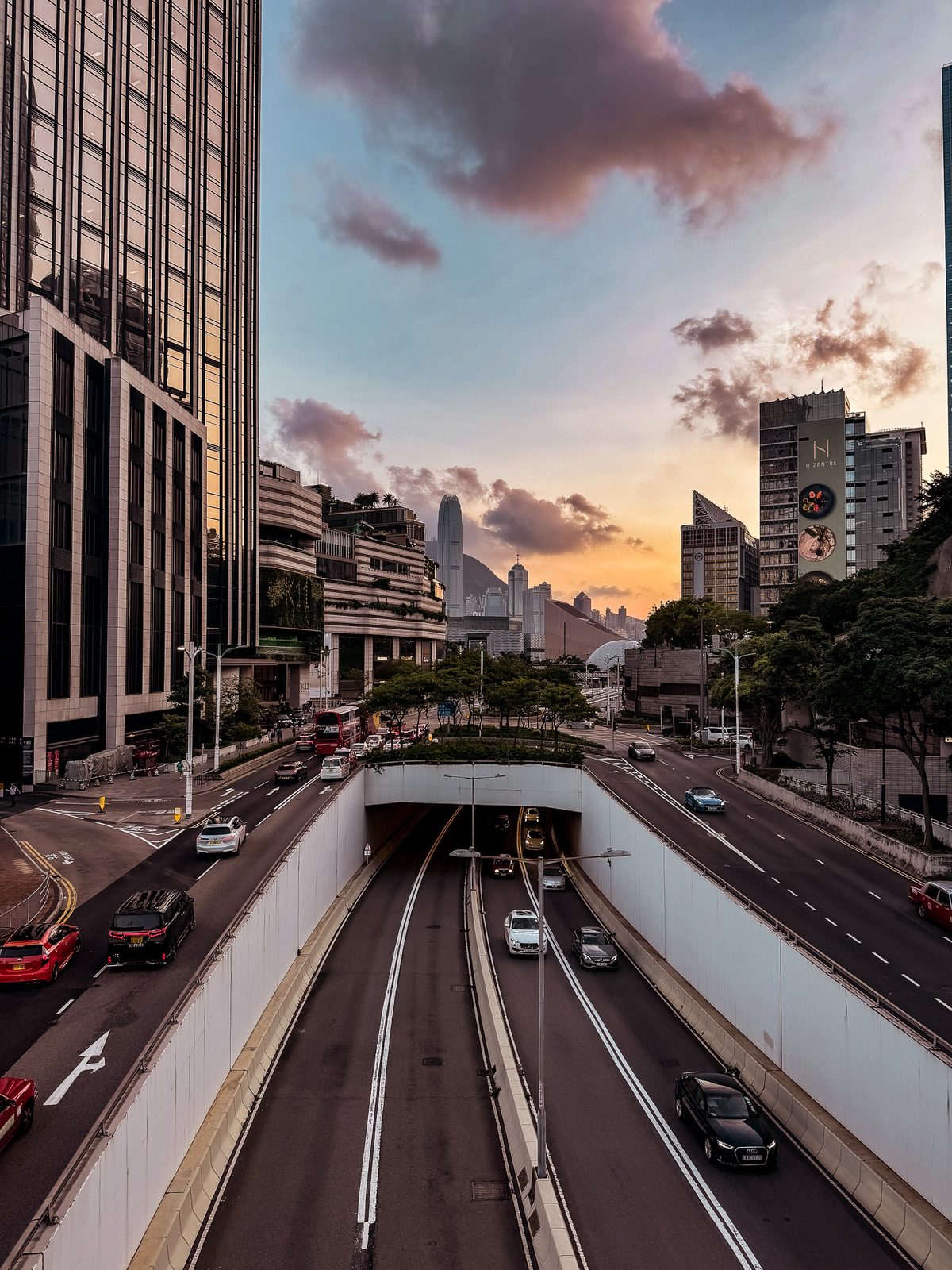 City highway at dusk with towers and clouds glowing overhead