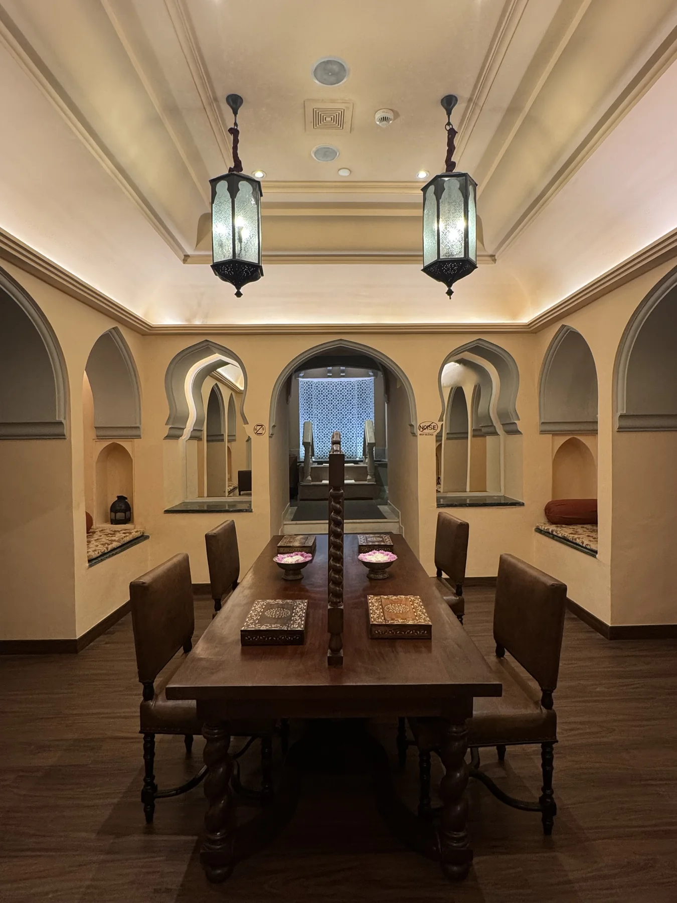 Moorish arched dining room with hanging lanterns and carved niche details