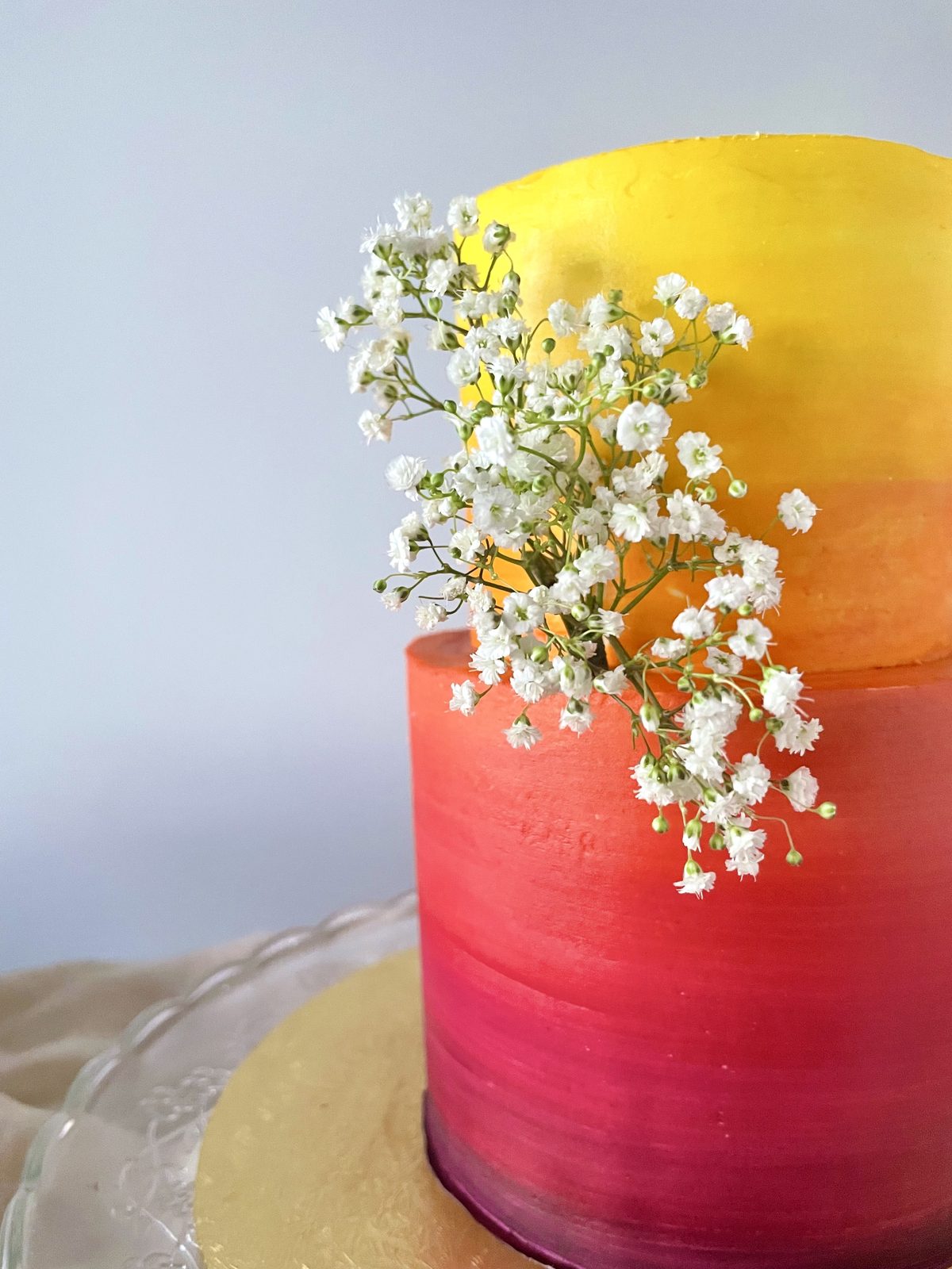Sunset-ombre cake in red and gold with sprigs of baby’s breath